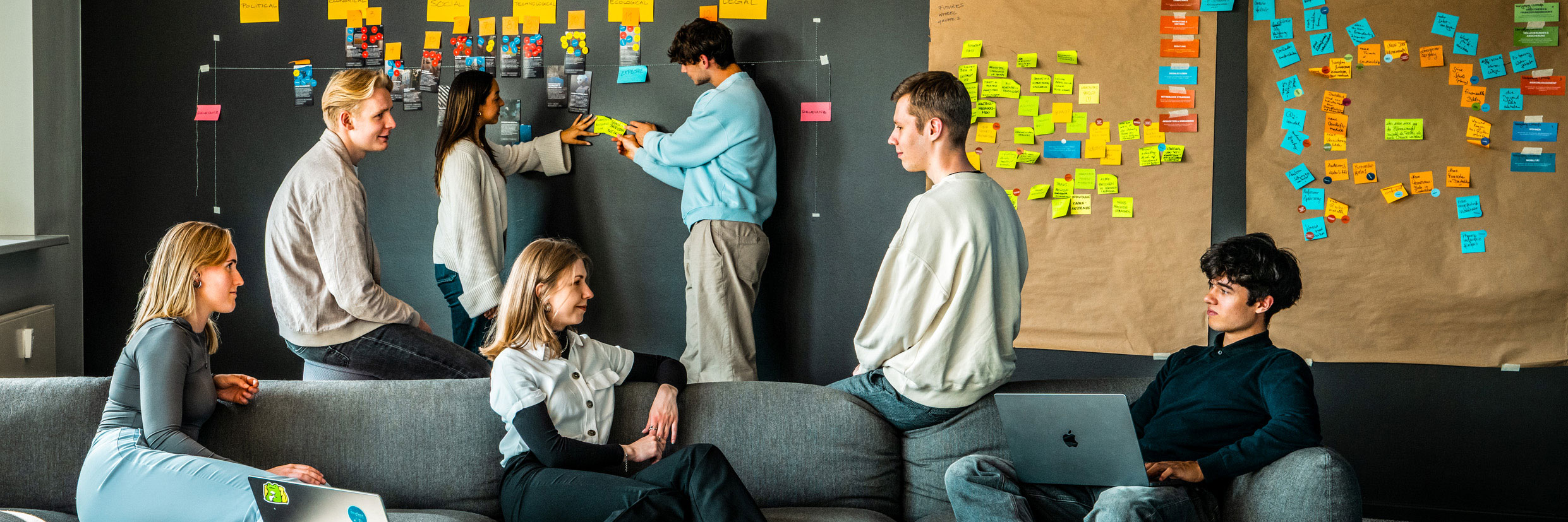 Mitarbeiter:innen der Star Finanz arbeiten kreativ in einem Workshop vor einer Wand voller Post-its und Projektkarten – agiles Arbeiten und Teamkultur.
