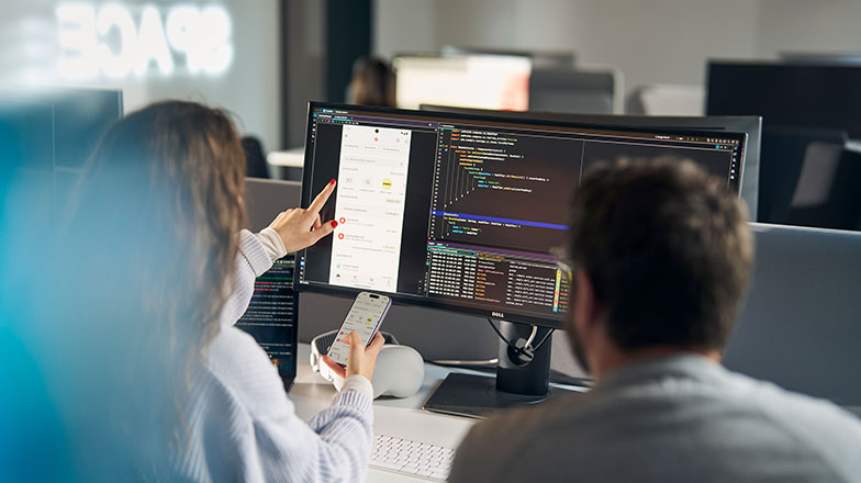 Mann und Frau programmieren gemeinsam an der Sparkassen App.