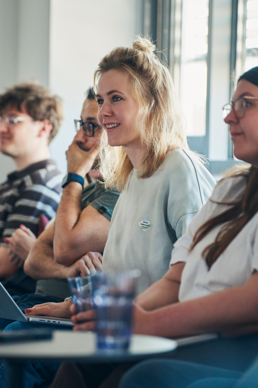 Mitarbeitende der App Factory lachend in einem Meeting