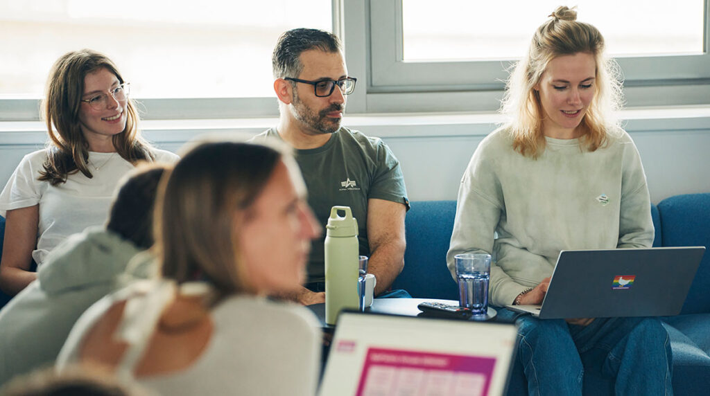 Mitarbeitende der App Factory sitzen gemeinsam in einem Meeting