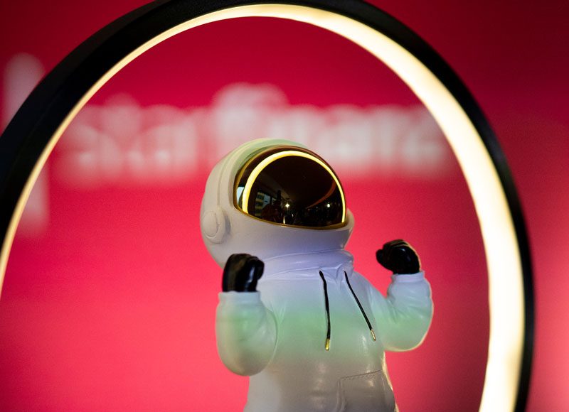 Ein kleine Astronautenfigur streckt zwei Fäuste in die Luft.