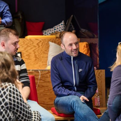 Kollegen sitzen bei einem Event zusammen und unterhalten sich.