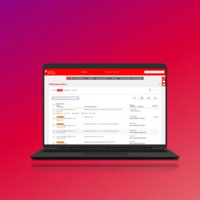 Auf einem schwarzen Laptop ist die Benutzeroberfläche eines E-Mail-Posteingangs mit einer roten Menüleiste vor einem Hintergrund mit einem Farbverlauf von Rosa bis Violett zu sehen.