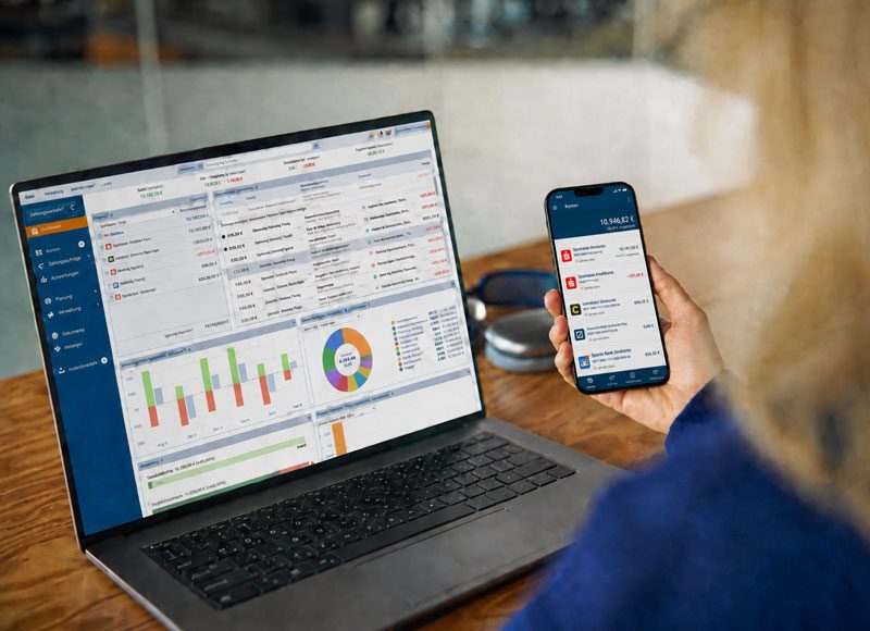 Aufgeklappter Laptopf auf dem die Software StarMoney geöffnet ist und daneben ein iPhone auf dem die StarMoney App geöffnet ist.
