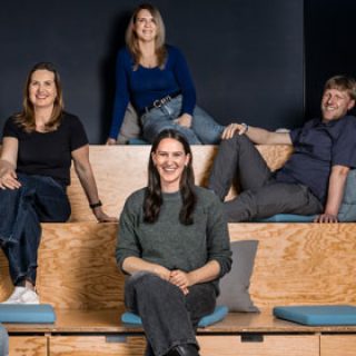 Ein Team des Bereichs People, Culture and Places der Star Finanz, bestehend aus Männern und Frauen sitzt auf einer Tribüne.